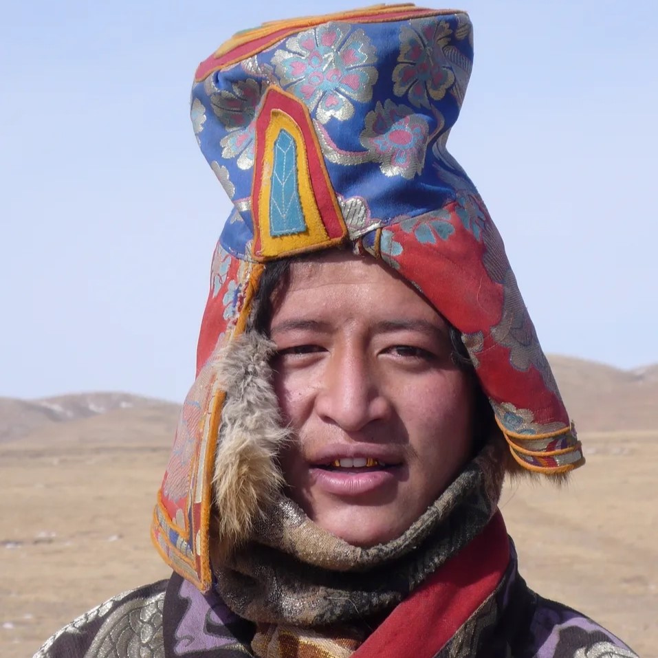 A man wearing a colorful hat and scarf.